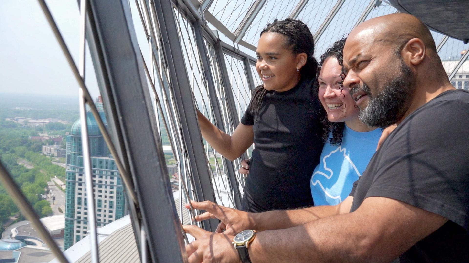 Family enjoying Niagara Falls views from Skylon Tower observation deck. 