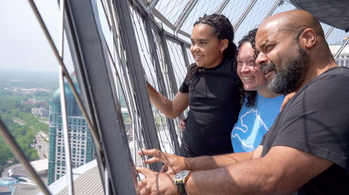 Family enjoying Niagara Falls views from Skylon Tower observation deck.