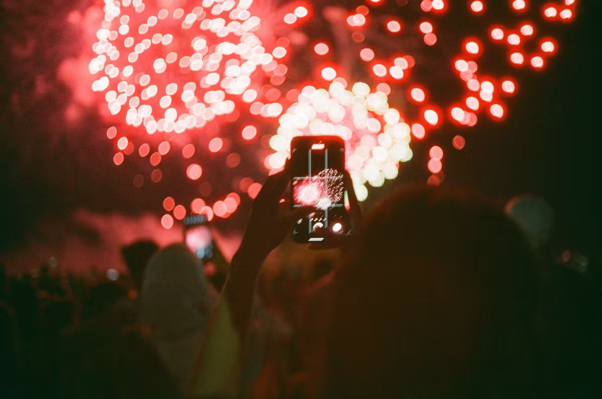 Visitors taking photos of fireworks over Niagara Falls.